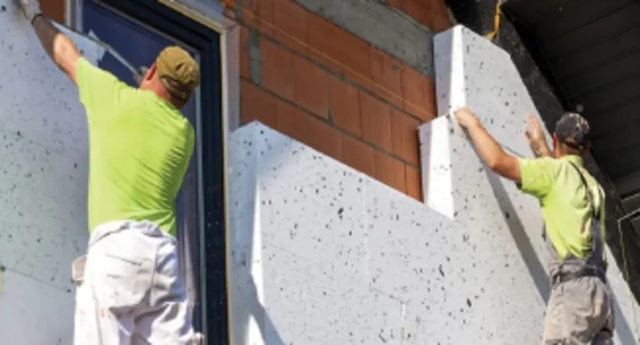 Workers installing exterior insulation panels